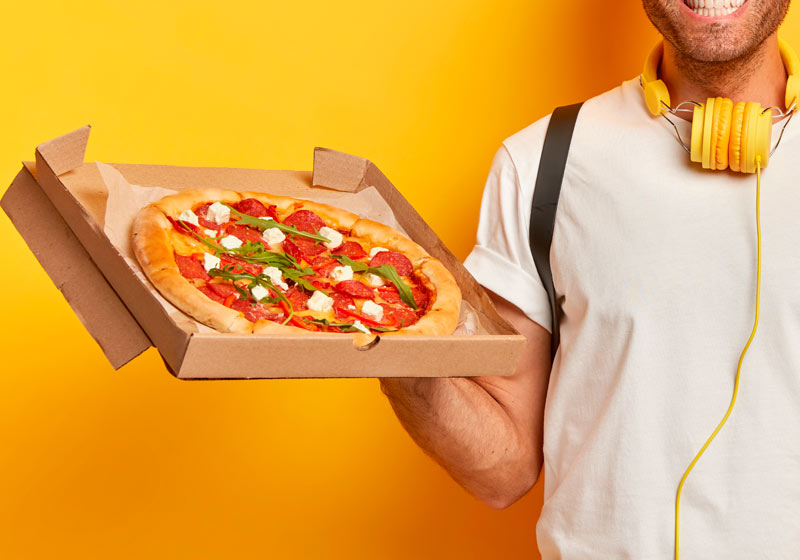 Homem segurando embalagem descartável de pizza